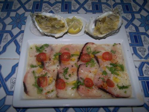 a plate of food with shrimp and tomatoes on a table at Villa Daba in Ghazoua
