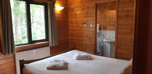 sypialnia z łóżkiem i umywalką w drewnianej kabinie w obiekcie Inverbeg Holiday Park w mieście Luss