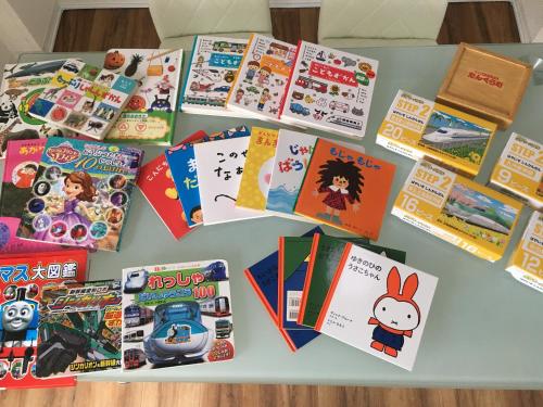 a table topped with lots of books and games at HOUSE K in Ichinomiya