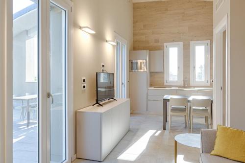 a living room with a tv and a kitchen at Homingarda Apartments, Pool & Garden, Near Lake Garda and Center in Peschiera del Garda