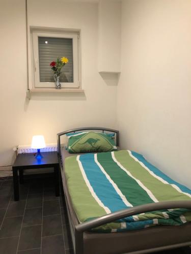 a bedroom with a bed and a table with a window at Rana's Zimmervermittlung in Bremen