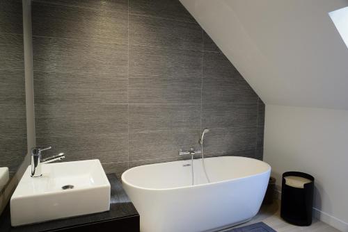 a bathroom with a sink and a white bath tub at Domaine des Bruyères in Sains-en-Amiénois