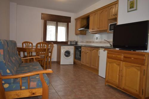 cocina con mesa y sillas y TV en Apartamentos Casa Esperanza - Ordesa, en Laspuña