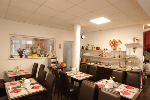 a restaurant with tables and chairs and a kitchen at Centro Hotel Oberhausen in Oberhausen