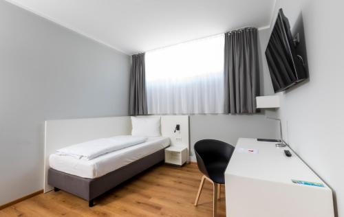 a hotel room with a bed and a chair at mk monteurzimmer eschborn in Eschborn