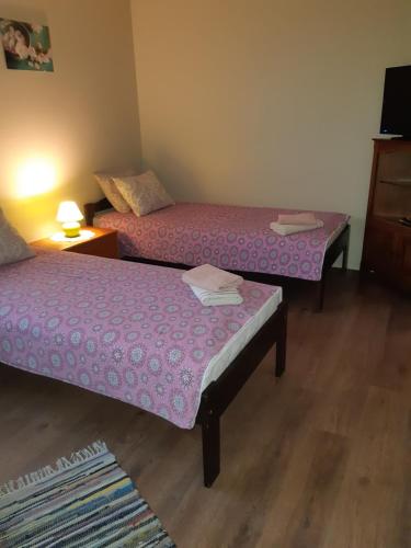 a room with two beds with pink sheets on them at Ovelia B&B in Kuressaare