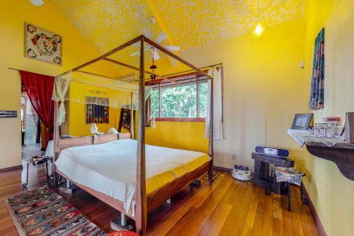 a bedroom with a canopy bed and yellow walls at Divina @ Framadani Estate in San Ignacio
