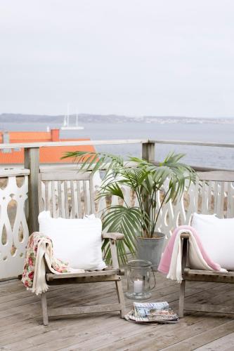 two benches on a deck with the ocean in the background at Strandflickornas Havshotell Lysekil in Lysekil