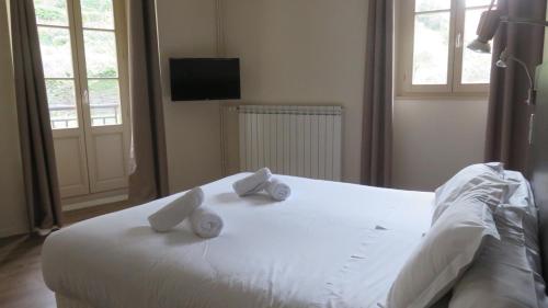 a bedroom with a white bed with two towels on it at Le Prieuré in Saint-Dalmas-de-Tende