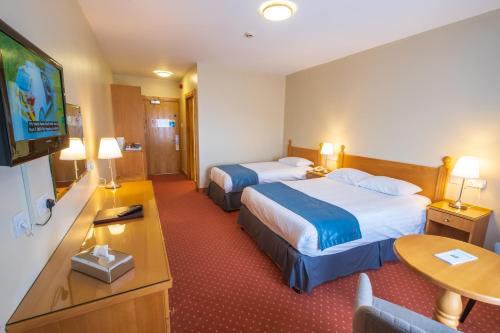 um quarto de hotel com duas camas e uma televisão de ecrã plano em Cromore Halt em Portstewart