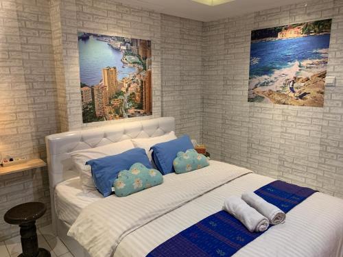- une chambre avec un grand lit blanc et des oreillers bleus dans l'établissement WOLKE Bellevue comfort Apartment, à Bandung