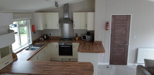 a kitchen with white cabinets and a stove top oven at Inverbeg Holiday Park in Luss