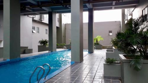een zwembad in het midden van een gebouw bij WOLKE Bellevue comfort Apartment in Bandung