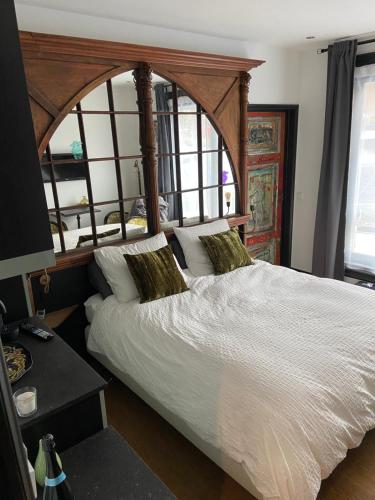 a bedroom with a large bed with a wooden headboard at Morpheus in Amsterdam
