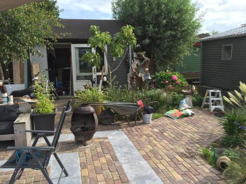 a backyard with a garden with a wheelbarrow and plants at Morpheus in Amsterdam