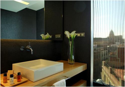 a bathroom with a sink and a vase with flowers at Ohla Barcelona in Barcelona
