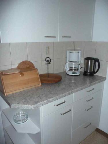 cocina con encimera, cafetera y electrodomésticos en Tga Mucki, en Savognin