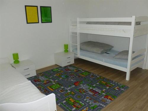 a bedroom with two bunk beds and a rug at Casa a Suglegl in Savognin