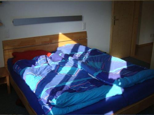 Un edredón azul en una cama en una habitación en Sot Spondas 15 en Savognin
