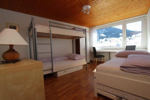 a bedroom with two bunk beds and a window at Tgesa Sunnmatt Nr. 13 in Savognin