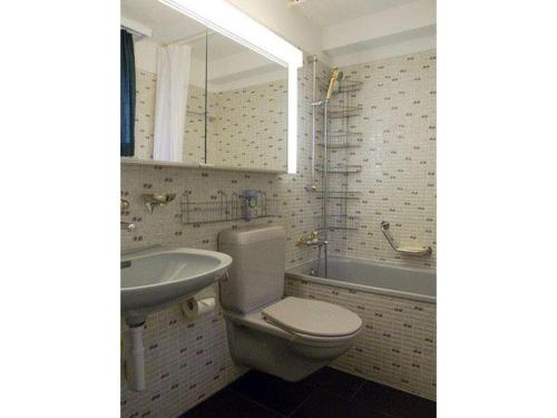 ein Badezimmer mit einem WC, einem Waschbecken und einer Badewanne in der Unterkunft Haus Viols 54 in Savognin