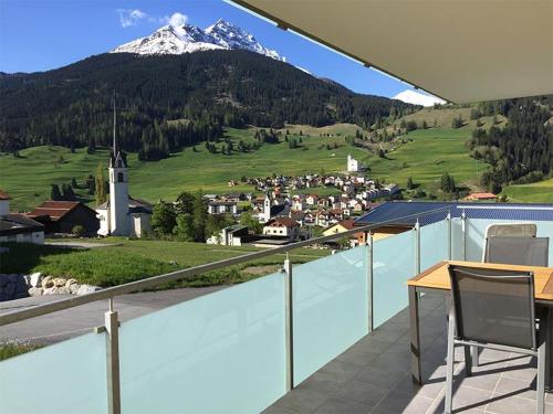 a table and chairs on a balcony with a mountain at Casa a Suglegl in Savognin