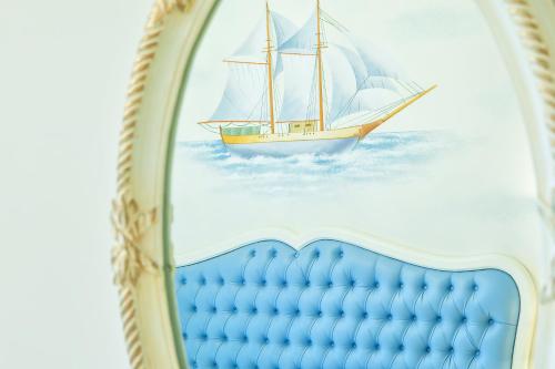 a mural of a sailboat on a wall next to a bed at Archontiko Kymis Boutique Hotel in Kymi