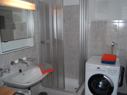 a bathroom with a washing machine and a washer at Ferienwohnung Hof Collet in Savognin