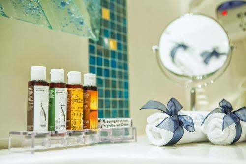 a bathroom counter with bottles of essential oils and towels at Archontiko Kymis Boutique Hotel in Kymi