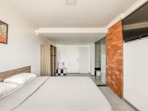 a bedroom with a bed and a brick wall at Hotel Traveling in Passo Fundo