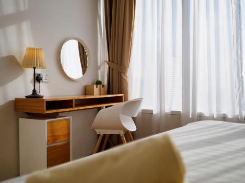 a bedroom with a bed and a desk and a mirror at The Penthouse KLCC in Kuala Lumpur