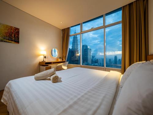 a hotel room with a large bed with a large window at The Penthouse KLCC in Kuala Lumpur