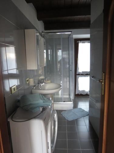 y baño con lavadora y lavamanos. en Maison Jasmine en Aosta