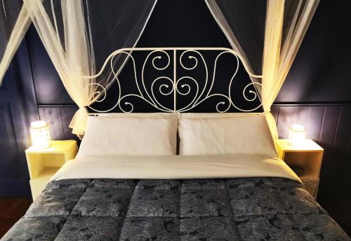 a bedroom with a black and white bed with two lamps at Ricordi di Viaggio, maison retrò in Trieste