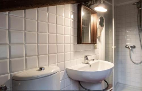 La salle de bains blanche est pourvue d'un lavabo et de toilettes. dans l'établissement The attic of Milan with terrace city view, à Milan