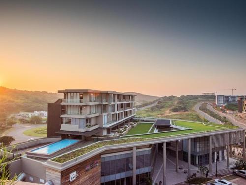 a building with a pool in front of it at No 2 Heleza Blvd Sibaya, Oceandune, Umhlanga Durban in Umdloti