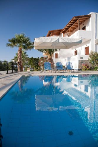 a swimming pool with chairs and an umbrella at Villa Michalis in Istro