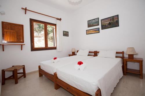 een slaapkamer met een groot wit bed met rode bloemen erop bij Villa Michalis in Istron