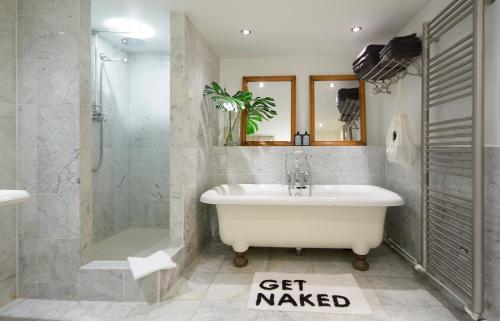 a bathroom with a tub and a shower and a sink at The Canal View Apartment in Amsterdam