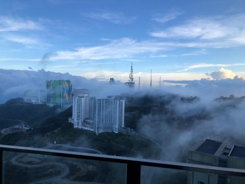 a view of a foggy city with buildings on a mountain at Sky D'Mont Suites in Genting Highlands