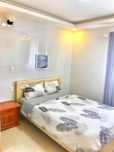 1 dormitorio con cama y mesa de madera en Hoang Vu Guest House en Dalat