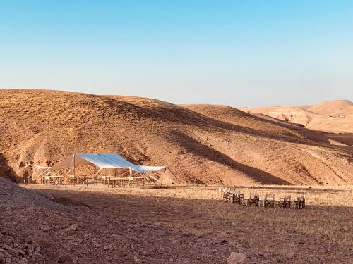 a tent in the middle of a desert with a mountain at Camp Cameleon in Marrakech
