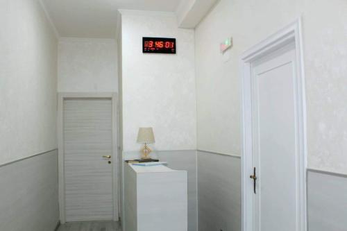 um quarto com um relógio na parede ao lado de uma porta em Oscar suite home em Roma