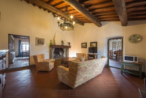 a living room with a couch and chairs and a table at Castello di Volpaia in Radda in Chianti