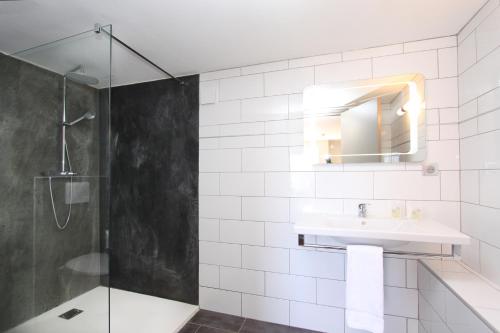 een badkamer met een douche, een wastafel en een spiegel bij Paese di Lava, Grand Ajaccio in Alata