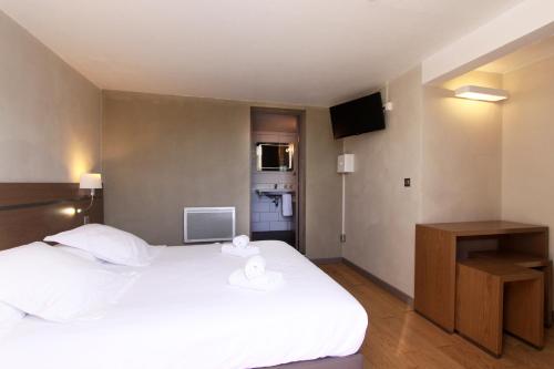 a bedroom with a large white bed and a television at Village de vacances Paese di Lava, Grand Ajaccio in Alata