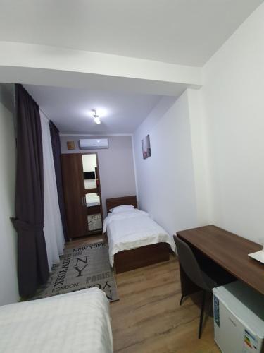 a small room with two beds and a desk at Vily Luxury Rooms in Focşani