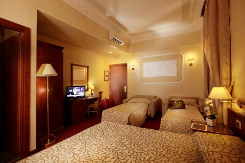ein Hotelzimmer mit 2 Betten und einem TV in der Unterkunft HS 311 in Rom