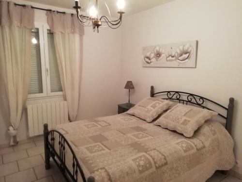 una camera da letto con un letto e un lampadario di la maison du saunier a Salin-de-Giraud