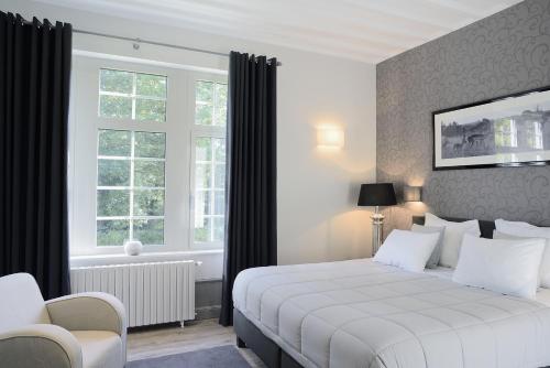 ein Schlafzimmer mit einem weißen Bett und einem Fenster in der Unterkunft Domaine des Bruyères in Sains-en-Amiénois